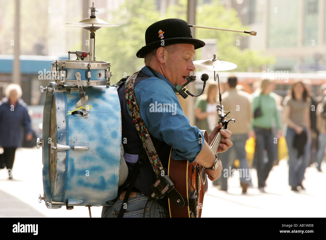 Musicista di strada one man band suonare la chitarra di concertina tamburo cembali Manchester City Centre country music urban spa di divertimenti Foto Stock