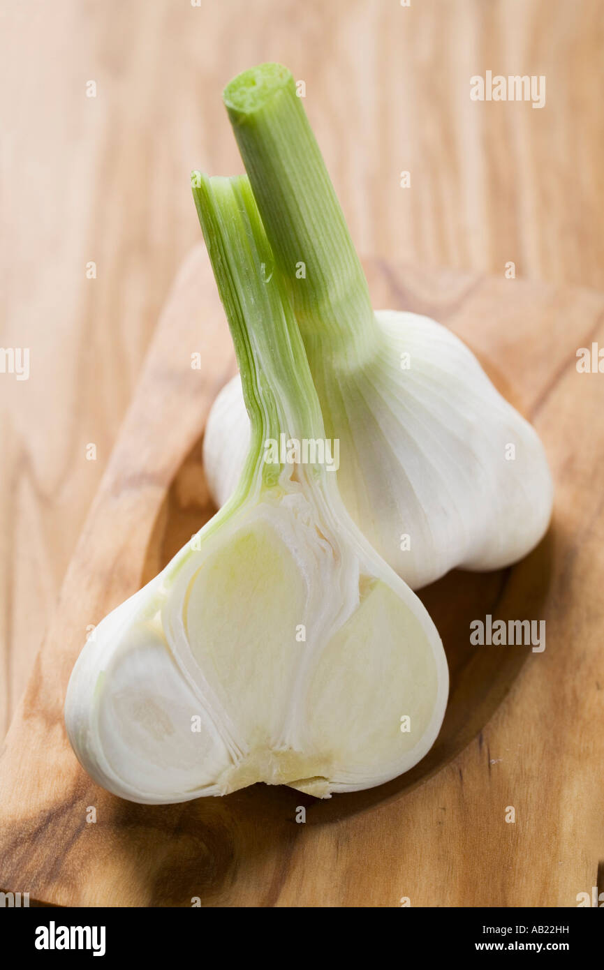 Intero e metà bulbo aglio sul tagliere di legno FoodCollection Foto Stock