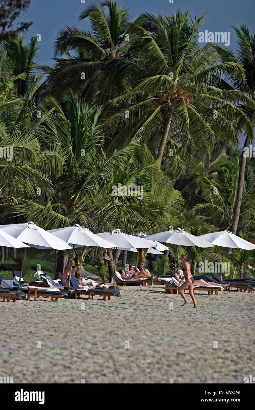 Palme e tonalità eleganti ombrelloni a Leela resort di lusso Mobor Beach Goa in India Foto Stock