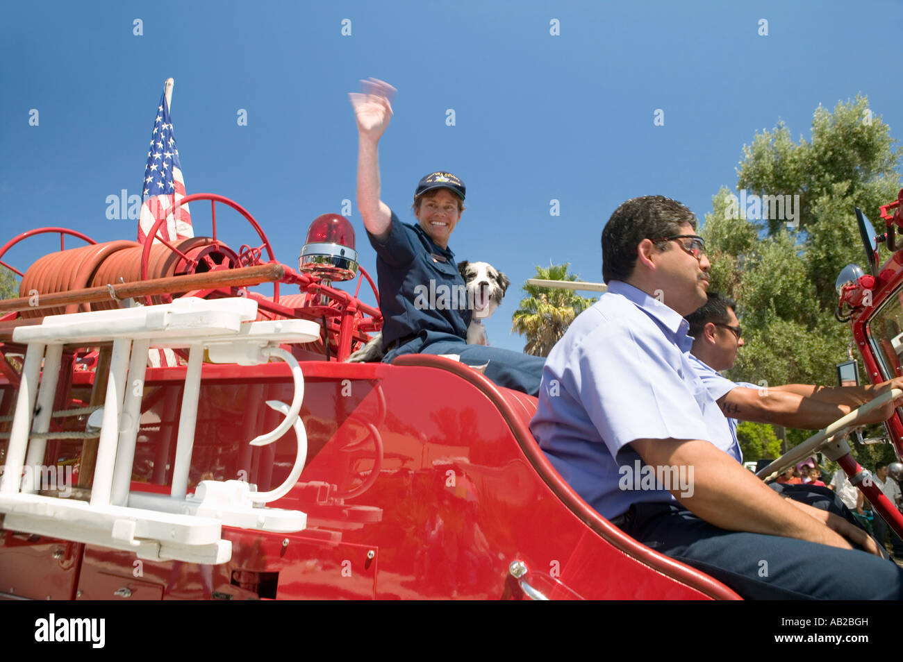 Camion dei pompieri e vigili del fuoco con il cane fanno la loro strada giù per la strada principale durante un quarto di luglio sfilata in Ojai CA Foto Stock