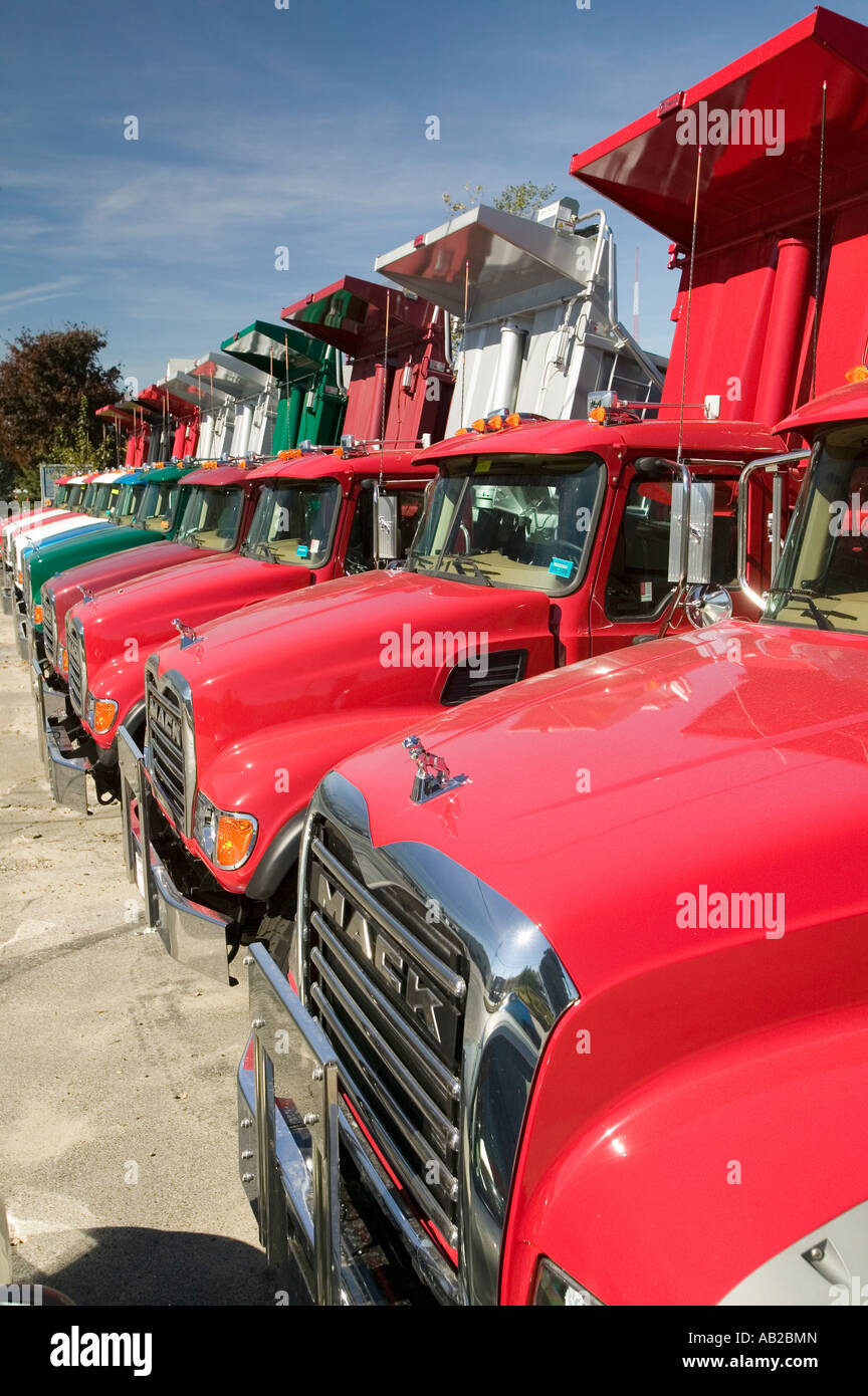 Rosso brillante Mack autocarri con cassone ribaltabile linea la strada in una fila nel Maine vicino al nuovo confine Hampshire Foto Stock