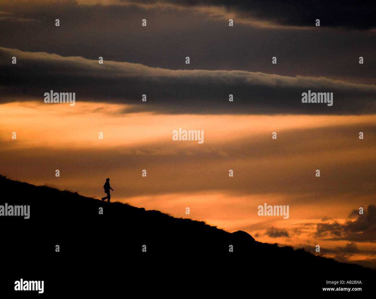 Un stagliano walker discendente da Arthur' Seat, Edimburgo. Foto Stock