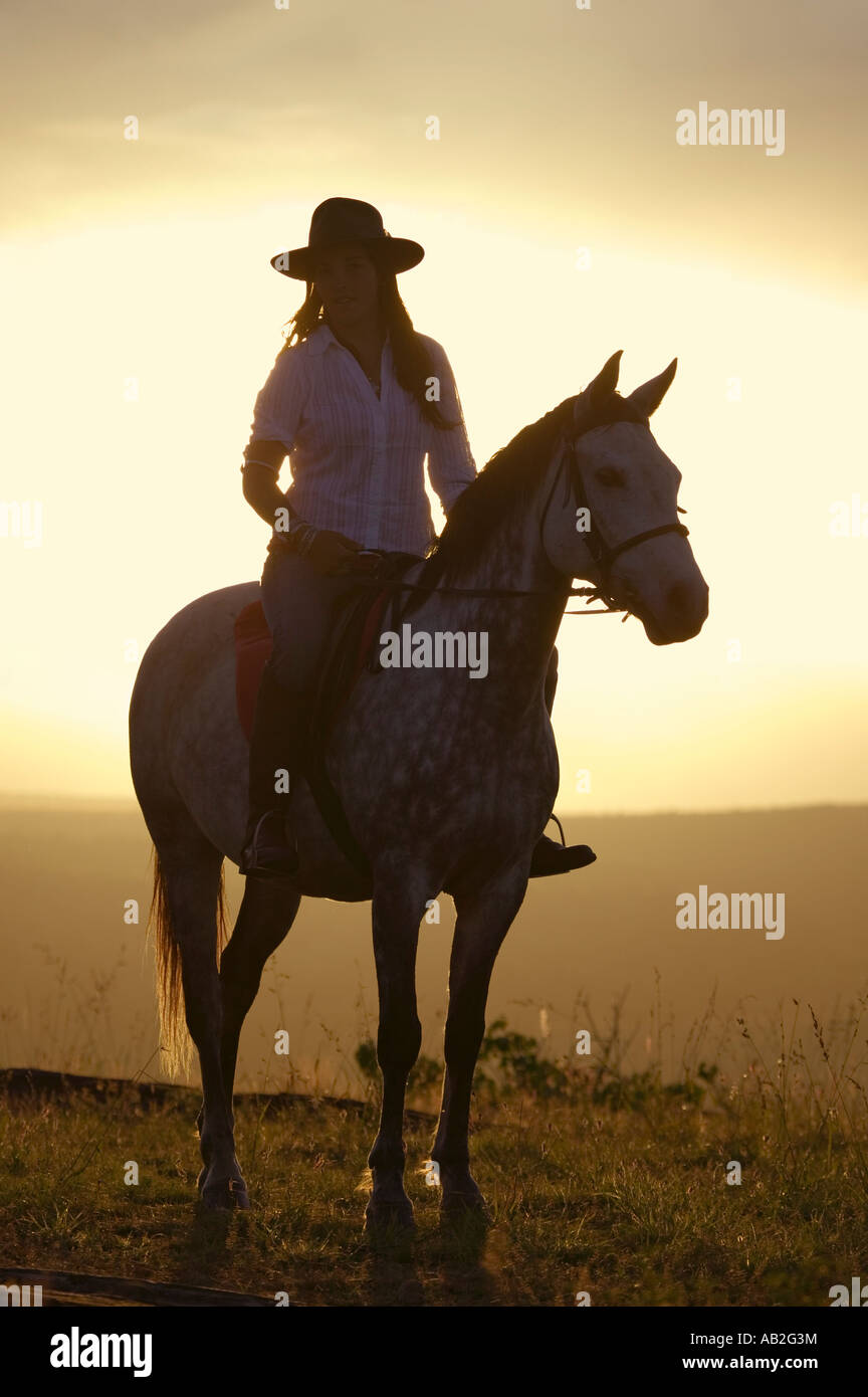 Femmina di cavaliere e cavallo a trascurare a Lewa Wildlife Conservancy nel nord Kenya Africa al tramonto Foto Stock