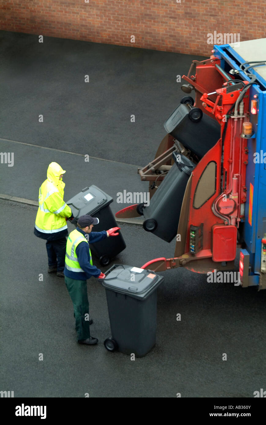 Binmen durante il lavoro per la raccolta dei rifiuti Foto Stock