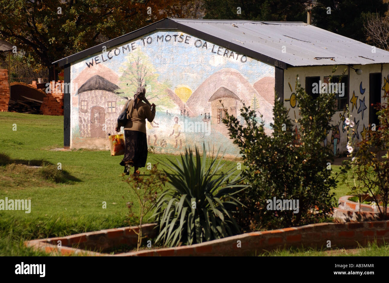 Una donna cammina da un orfanotrofio per bambini orfani di AIDS in Maseru, Lesotho Foto Stock