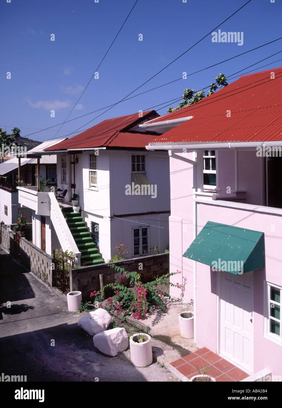 St Georges Grenada alloggiamento con tipico di acciaio ondulato telone utilizzato su tetti e dipinte di rosso brillante Foto Stock