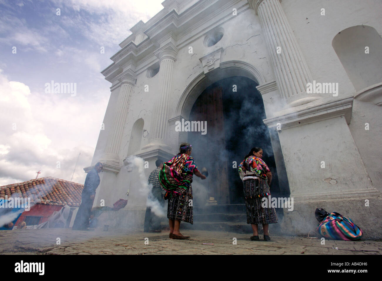 La gente del posto bruciando incenso e candele pregare presso l'entrata del Santo Tomas chiesa a Chichicastenango. Foto Stock