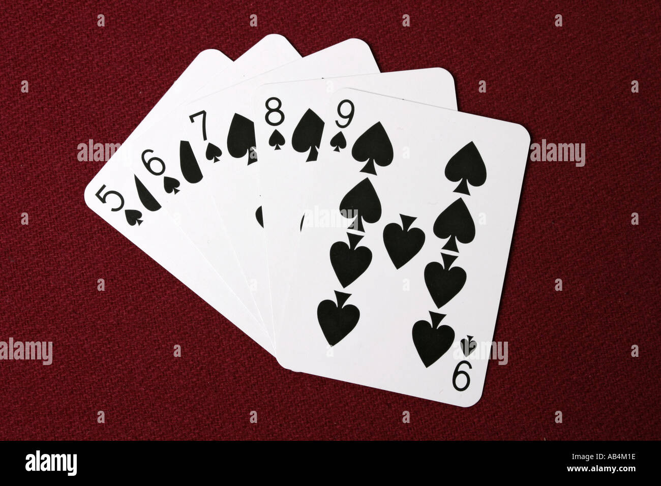 Un straight flush mano di poker carte ventaglio su un rosso tabella concessionari Foto Stock