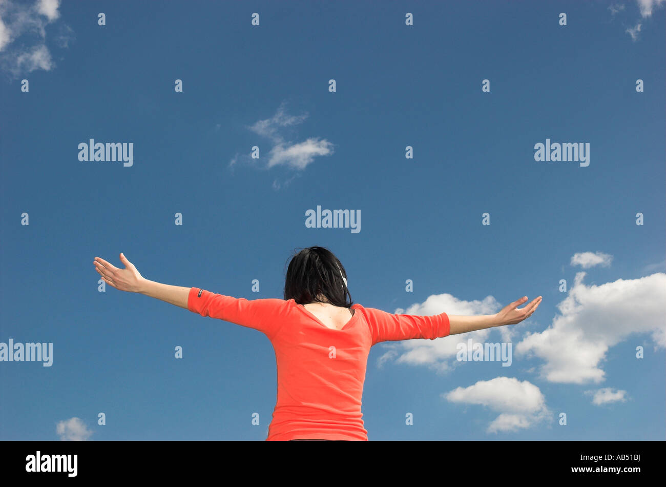 Giovane donna all'aperto con le braccia aperte vista posteriore Foto Stock