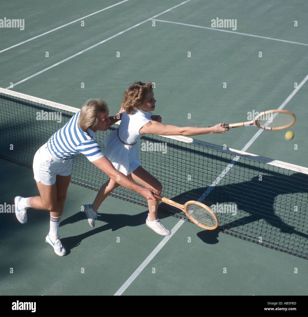 Giovane uomo e donna a caccia di palla sul campo da tennis Foto Stock