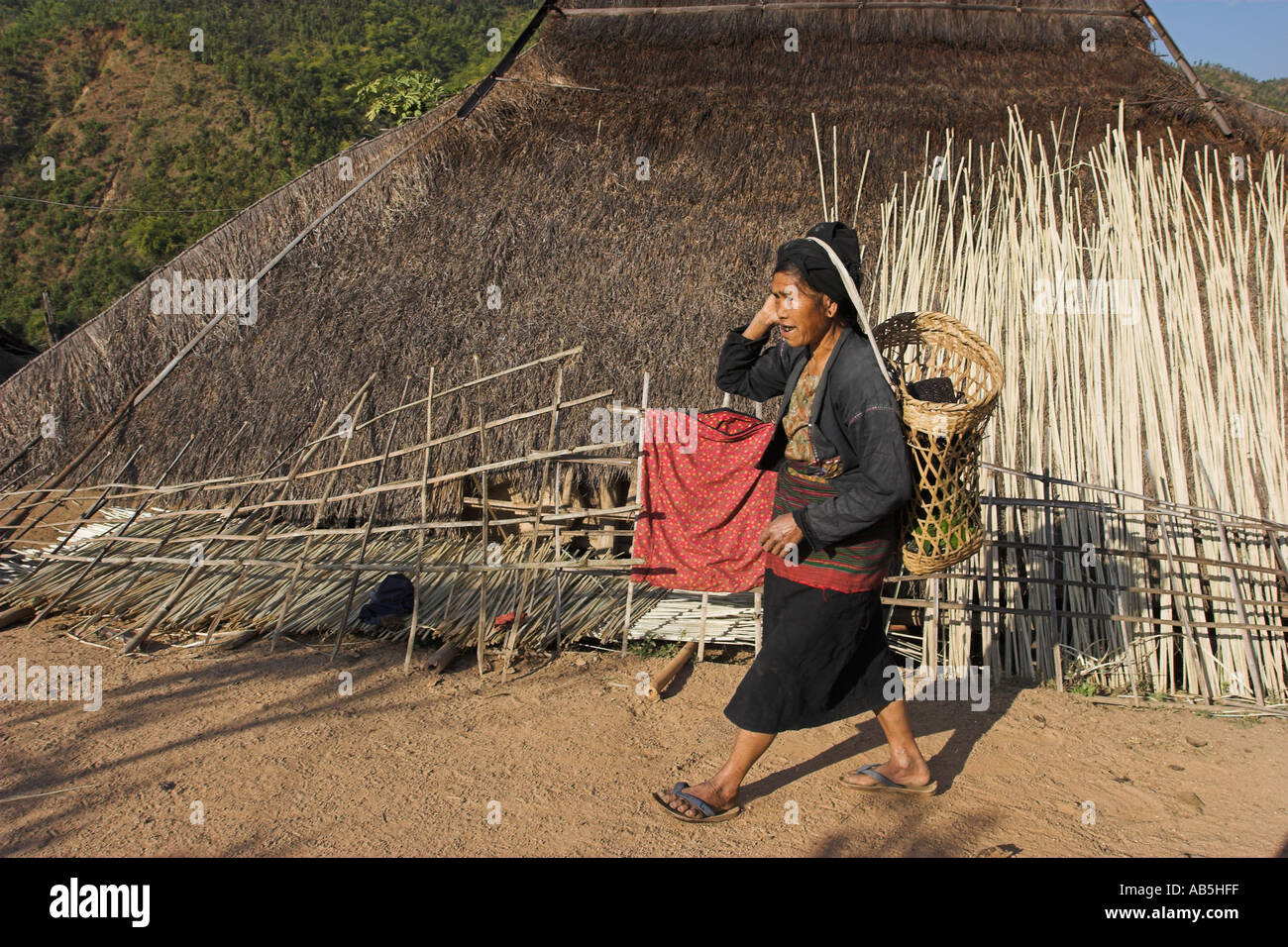 Myanmar stato Shan Kengtung Ann Village Lady camminare davanti casa di paglia Foto Stock