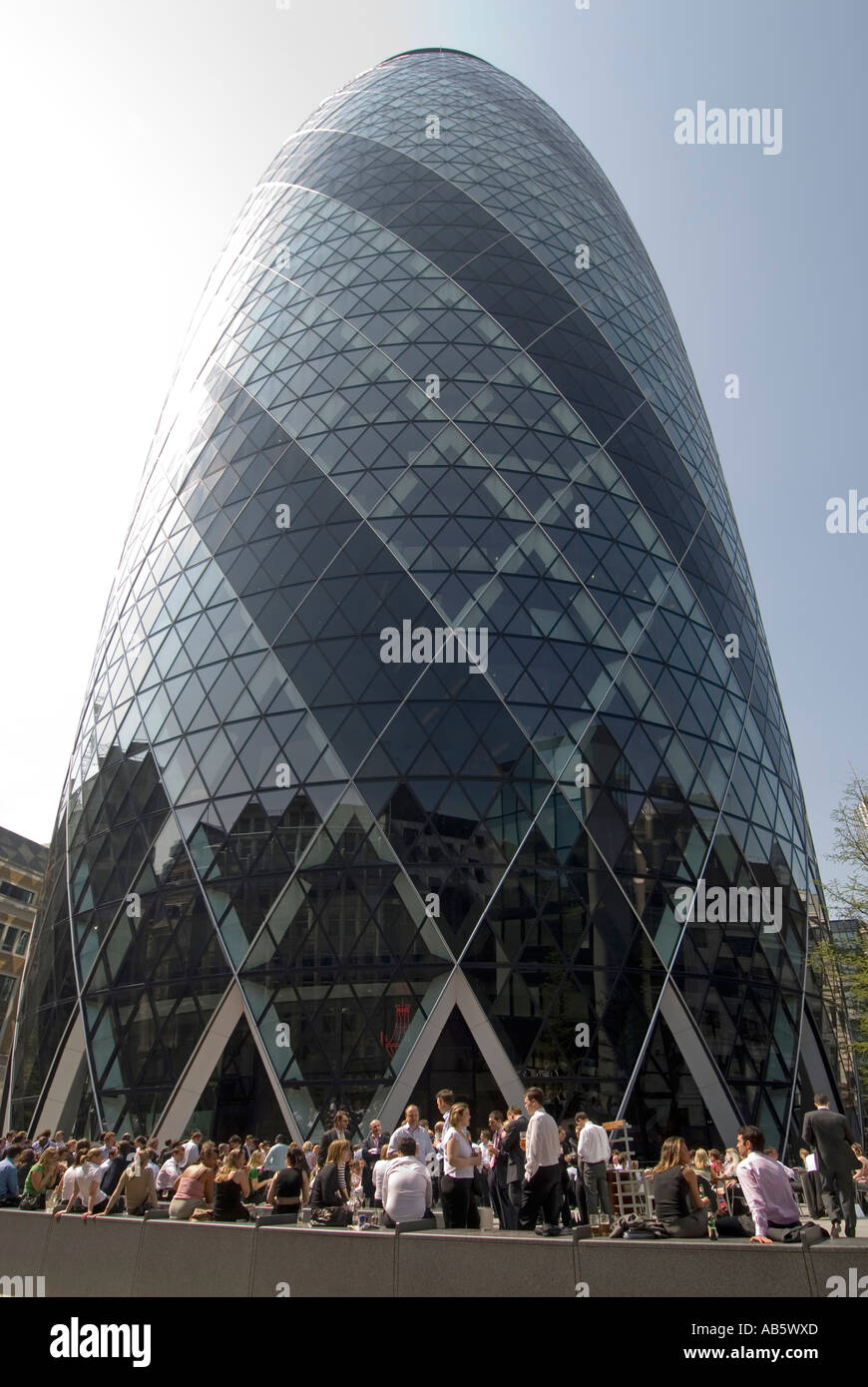 Close up di forma insolita Gherkin ufficio moderno grattacielo landmark building City di Londra Inghilterra sede Regno Unito i lavoratori in pausa pranzo caldo giorno di primavera Foto Stock
