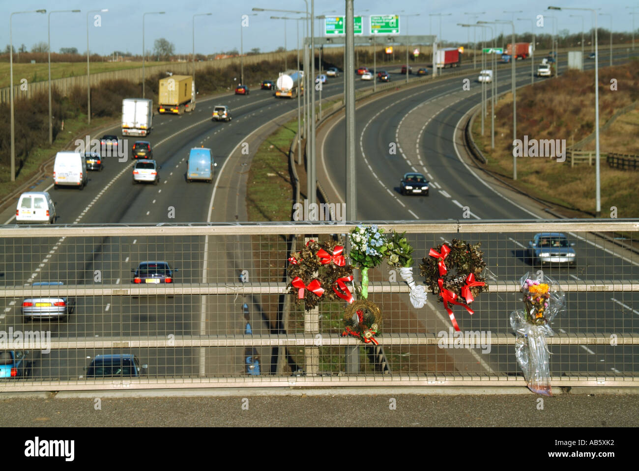 Tributi floreali posti su parapetti su ponte pedonale sopra la strada a doppia carreggiata a sei corsie a seguito di una fatalità nell'Essex Inghilterra Regno Unito Foto Stock