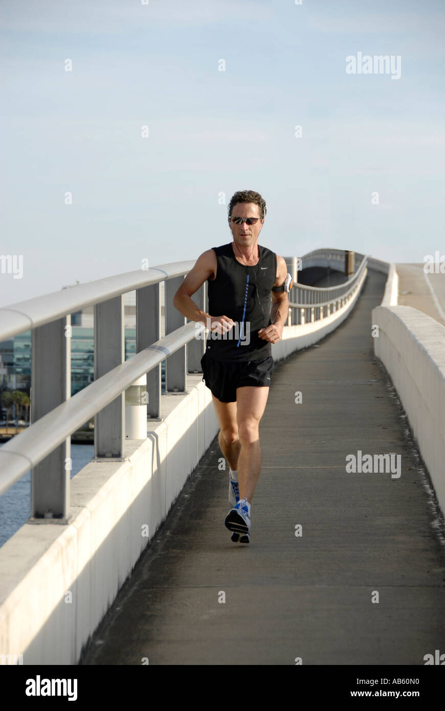 Maschio adulto corre attraverso un ponte a Jacksonville in Florida FL per esercizio e salute Foto Stock