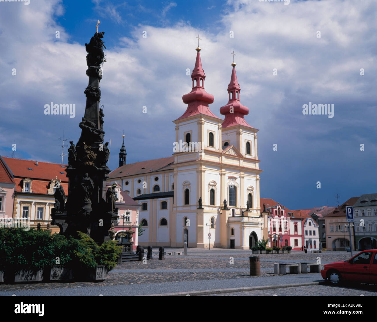Colonna della Peste e colorata chiesa vista sulla pittoresca piazza principale, Kadan, nel nord della Repubblica ceca. Foto Stock