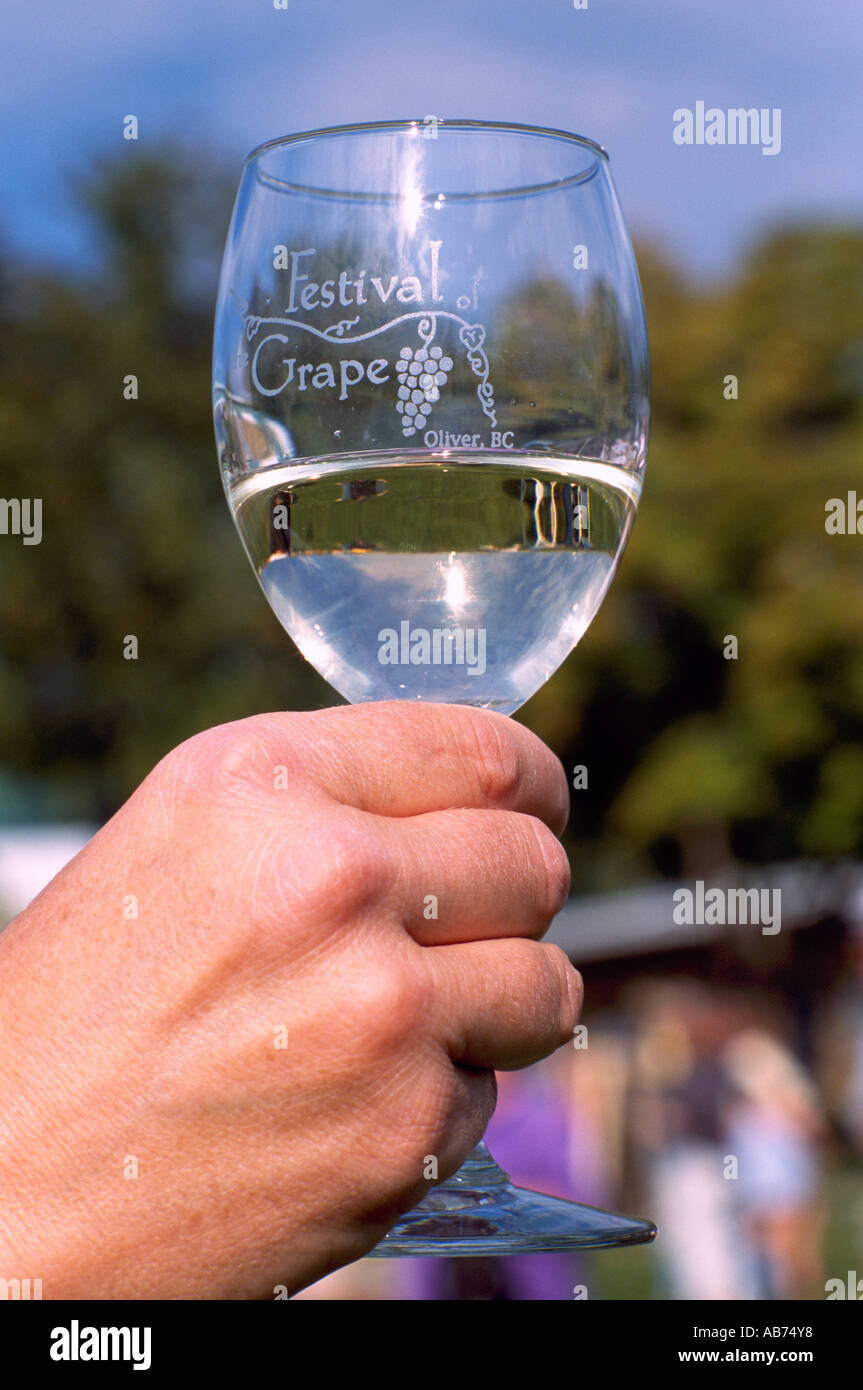 Degustatore di vini con in mano un bicchiere di vino Bianco al Festival dell'uva, Oliver, BC, British Columbia, Canada Foto Stock