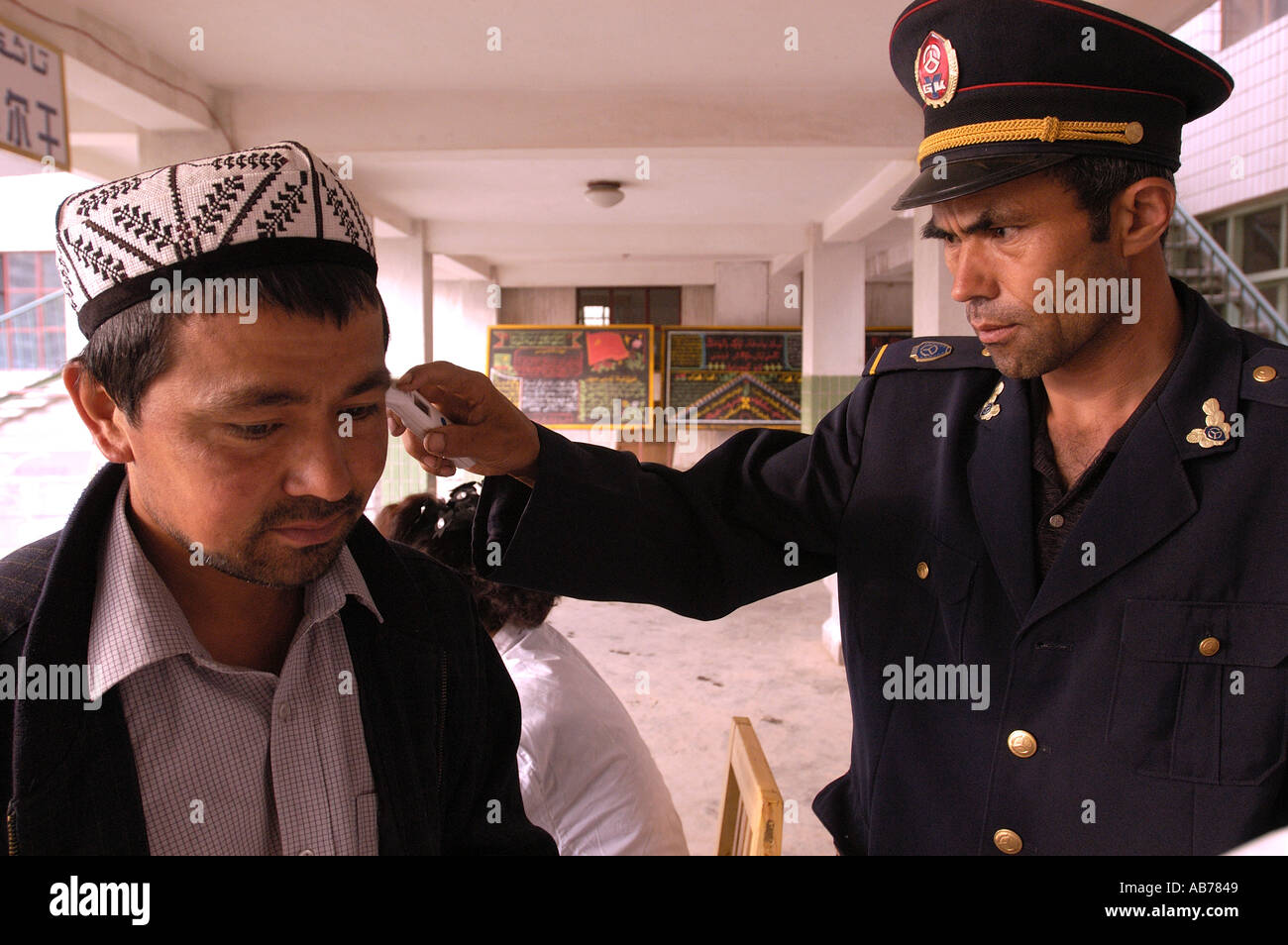 Temperatura essendo presa dell'uomo alla salute SARS checkpoint in Kashgar alla stazione degli autobus in Cina 2004 Foto Stock