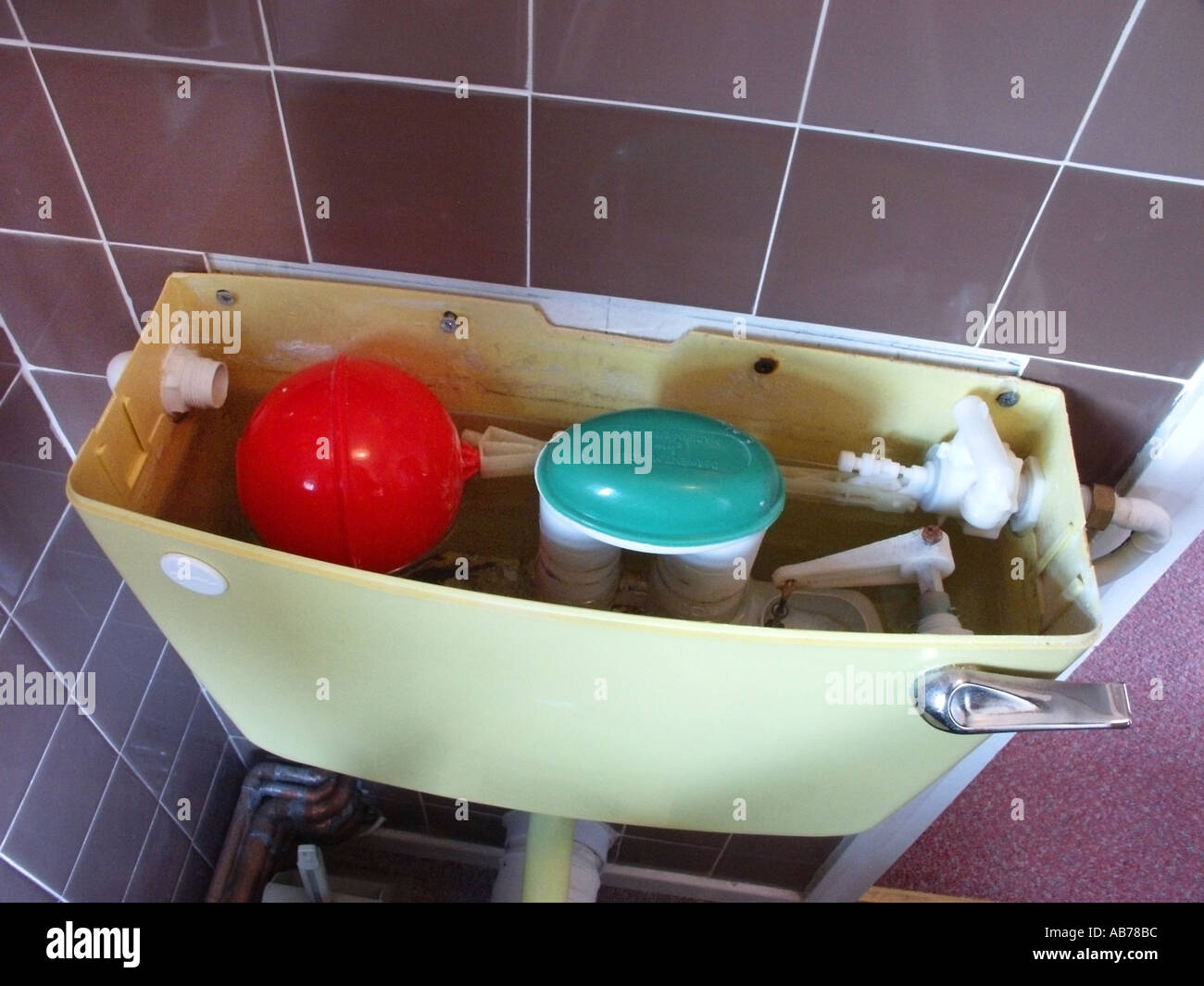 Più vecchio stile acqua cisterna di deposito per il lavaggio per WC tazza igienica viene sostituita con una più economica tipo coperchio rimosso Foto Stock