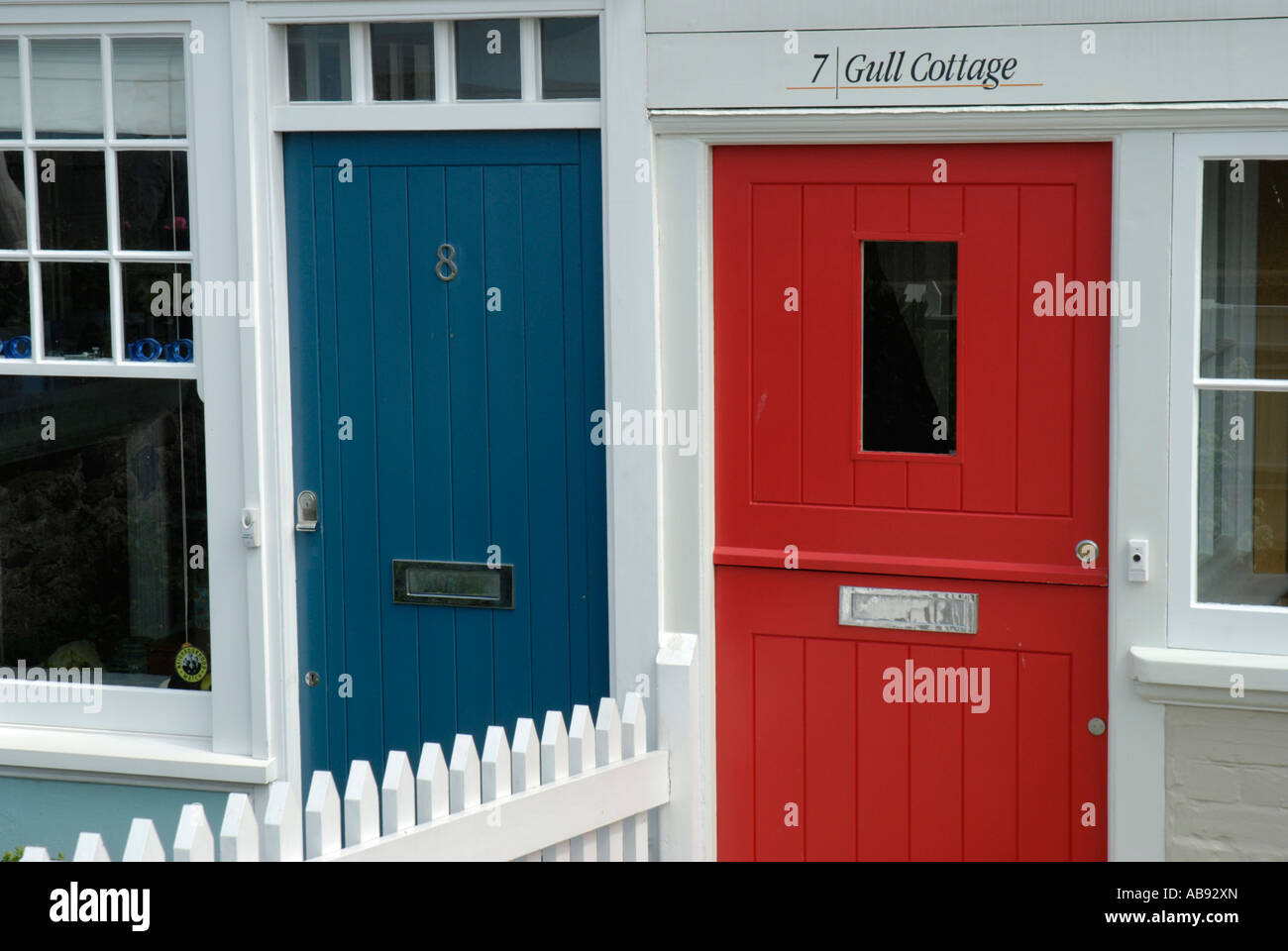 Close up di rosso e blu sportelli sul lungomare cottages whitstable kent england Foto Stock