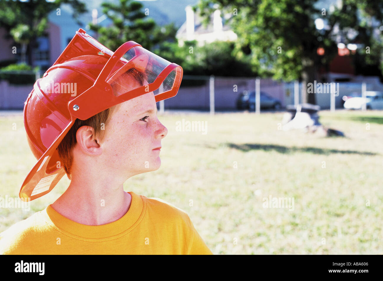 Ragazzo che indossa un casco per gli allarmi antincendio Foto Stock