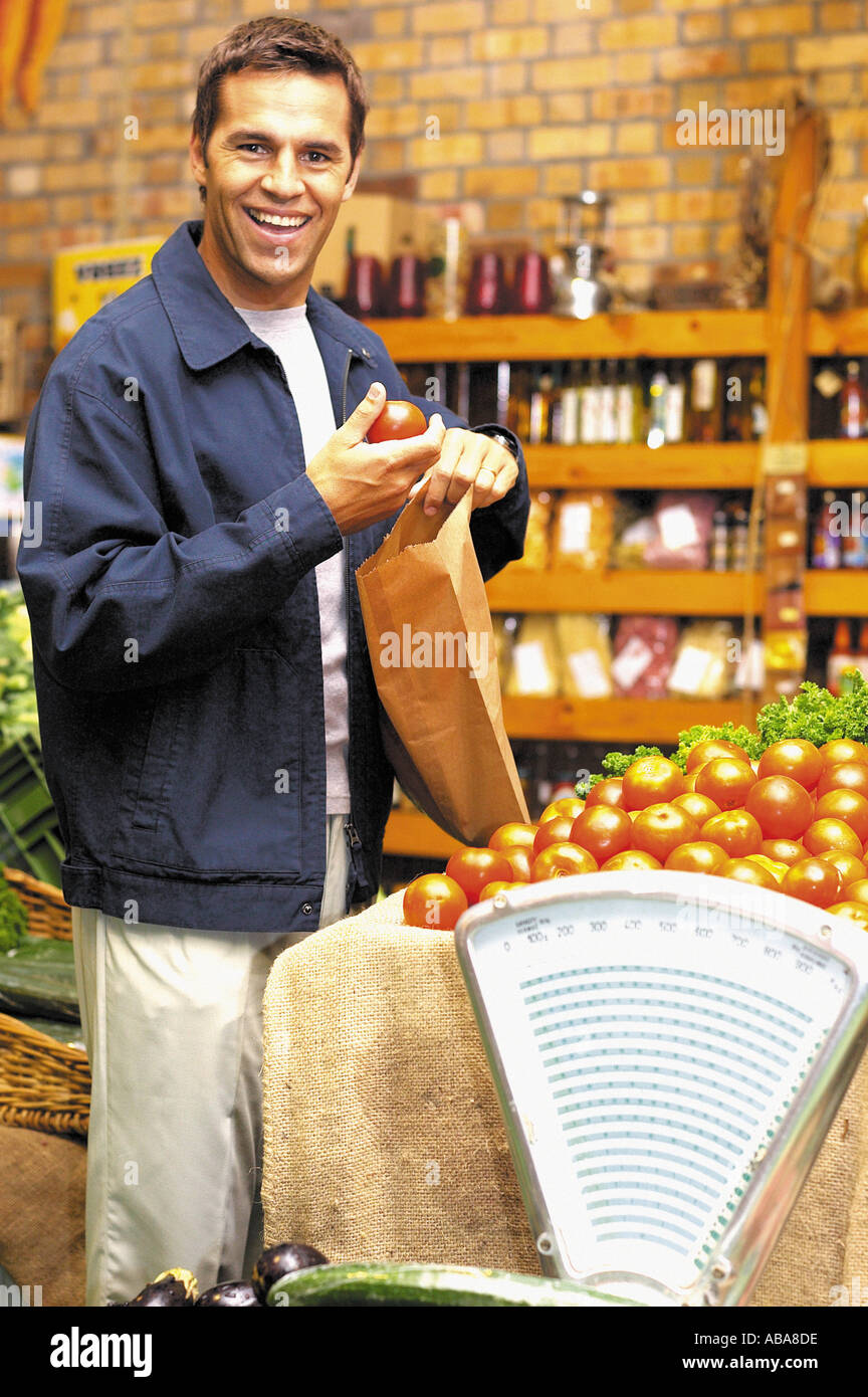 Uomo con pomodoro e sacchetto di carta Foto Stock