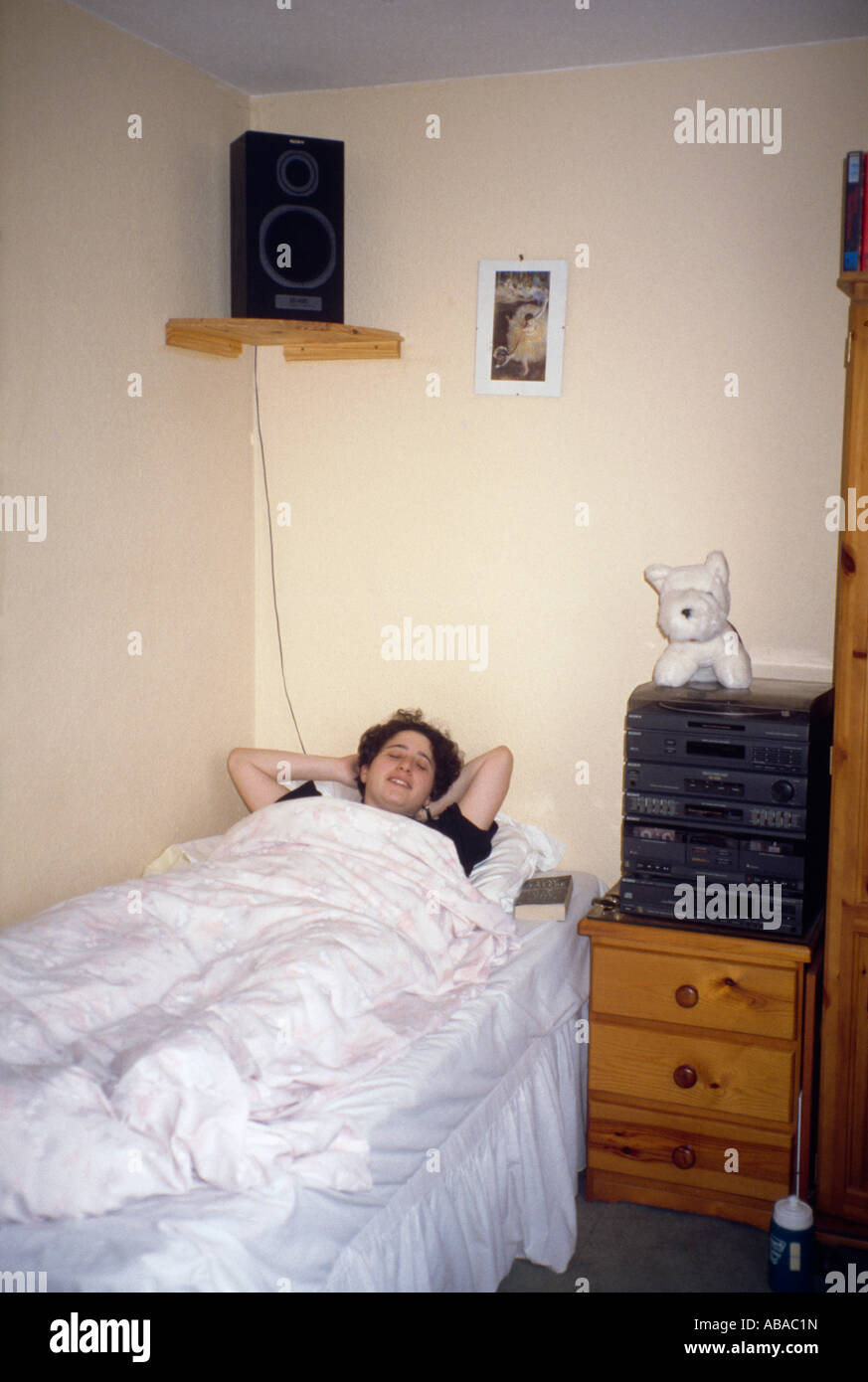 Adolescente a letto con hi-fi Foto Stock