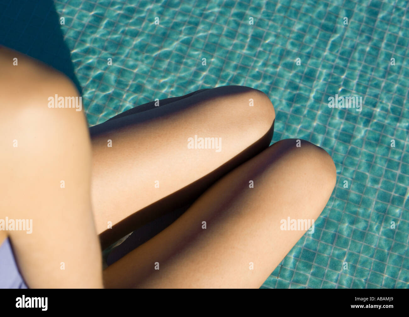 Alle spalle della donna e gambe visto nel corso dell acqua di piscina, ad alto angolo di visione Foto Stock
