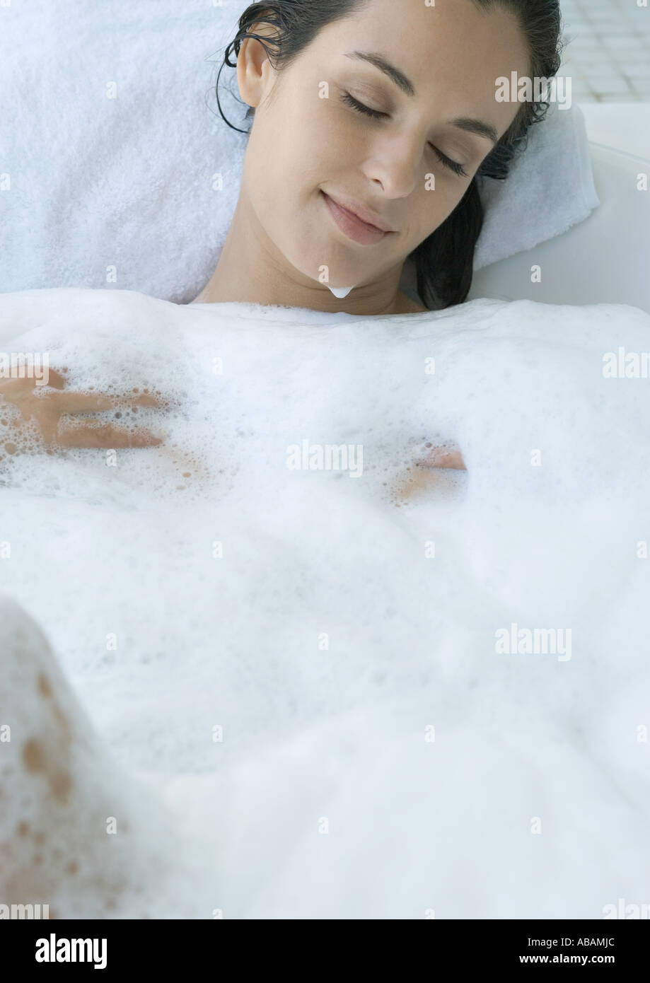 Donna reclinata in bagno di bolle Foto Stock