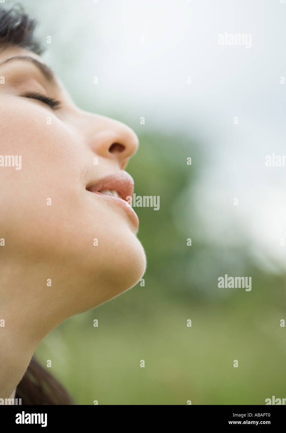 Donna di chiudere gli occhi e la testa tiltante indietro, close-up, vista laterale Foto Stock