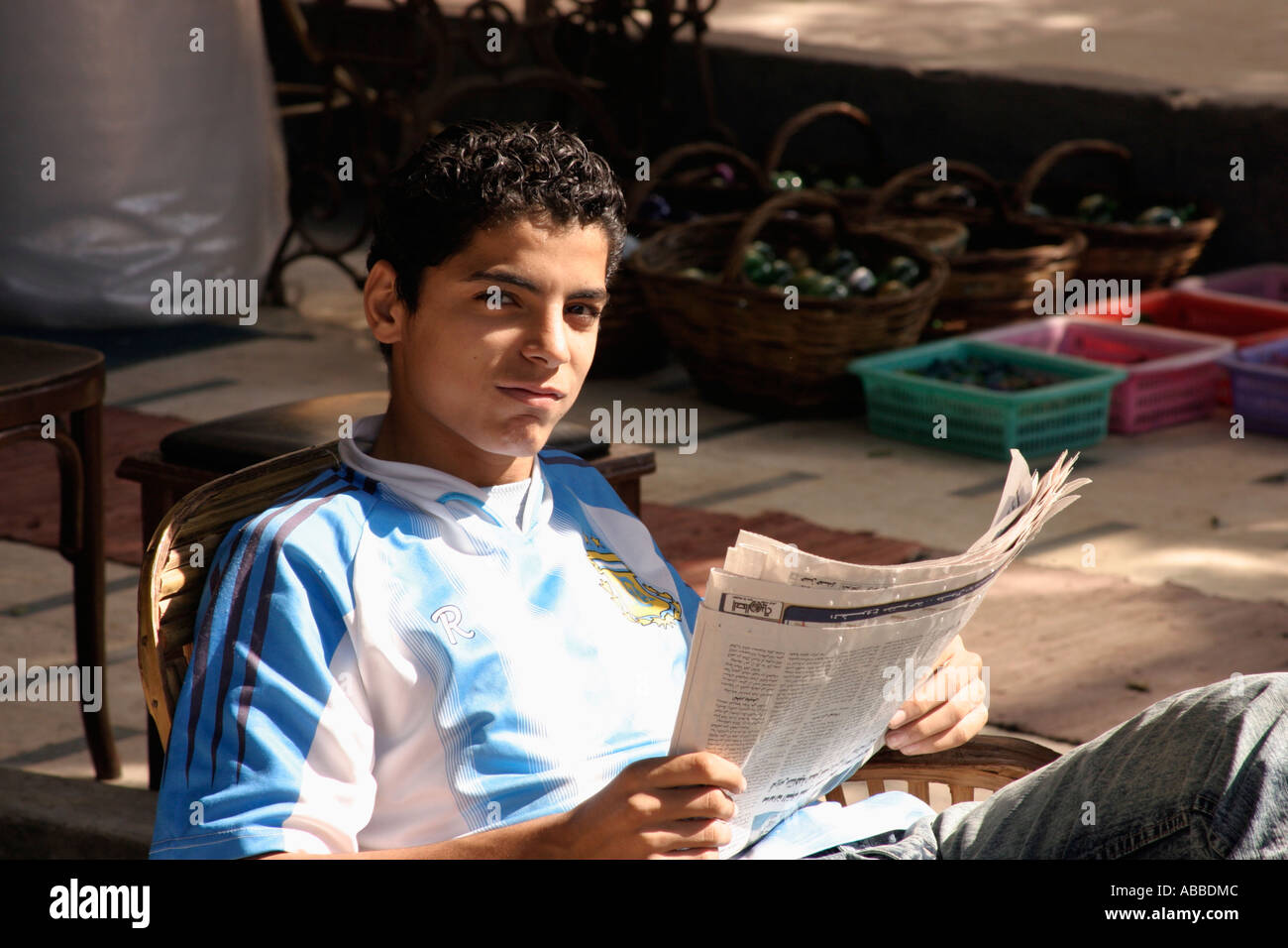 Giovane uomo egiziano leggendo il giornale Foto Stock