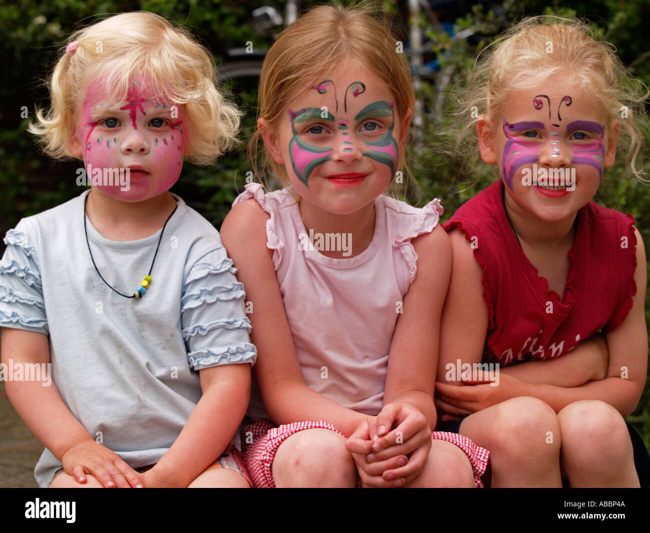 Tre bambine kids bambini amici con grasso schminked dipinto realizzato su facce amicizia Foto Stock