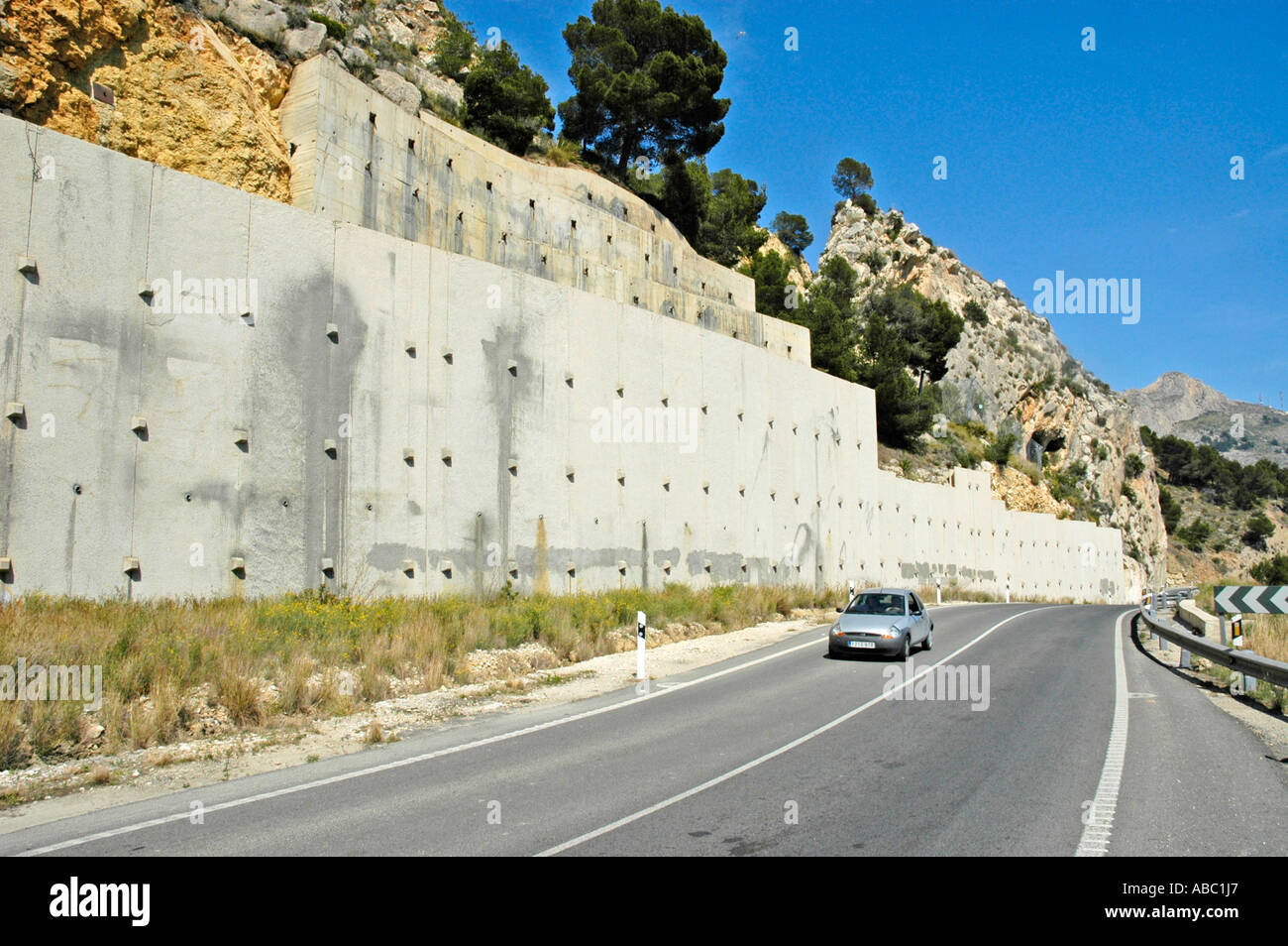 Auto faehrt auf der Kuestenstrasse, Steinmauer, Steinschlag, Bergrutsch, Befestigung, Altea, Costa Blanca, Spanien |Guida auto Foto Stock