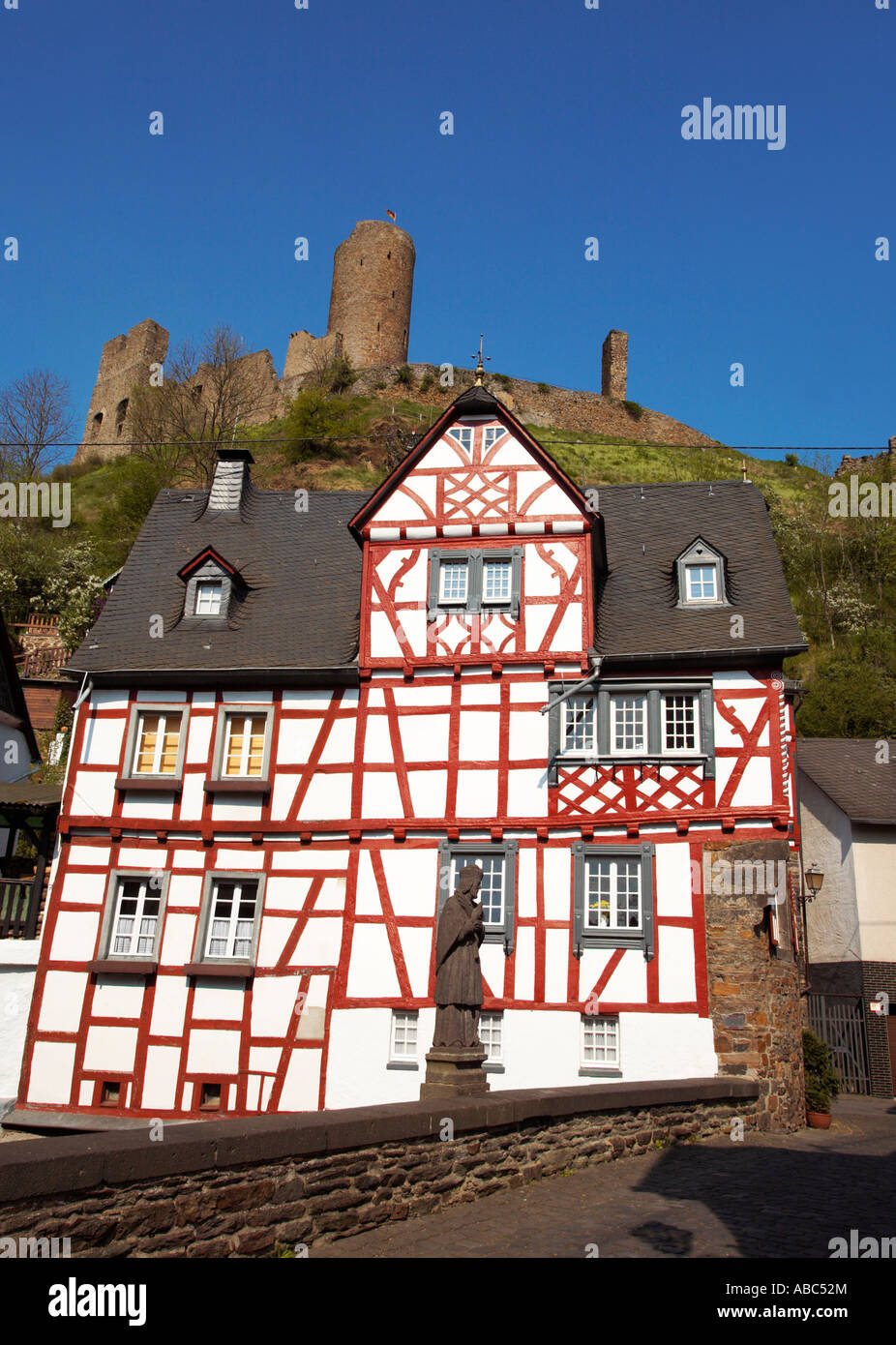 Statua di Giovanni apostolo sul ponte nella parte anteriore di un graticcio casa di Monreal con il castello Löwenburg sopra Foto Stock