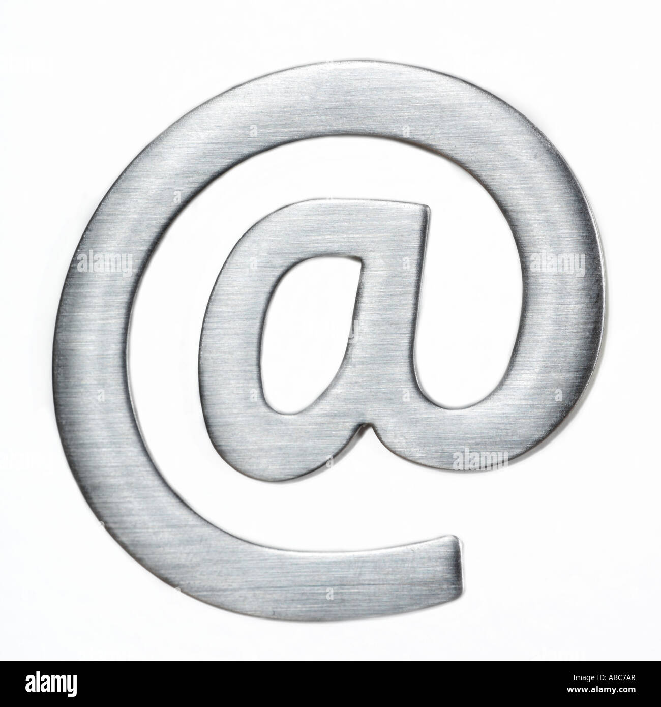 Arobase e mail segno spazzola in metallo su uno sfondo grigio Foto Stock