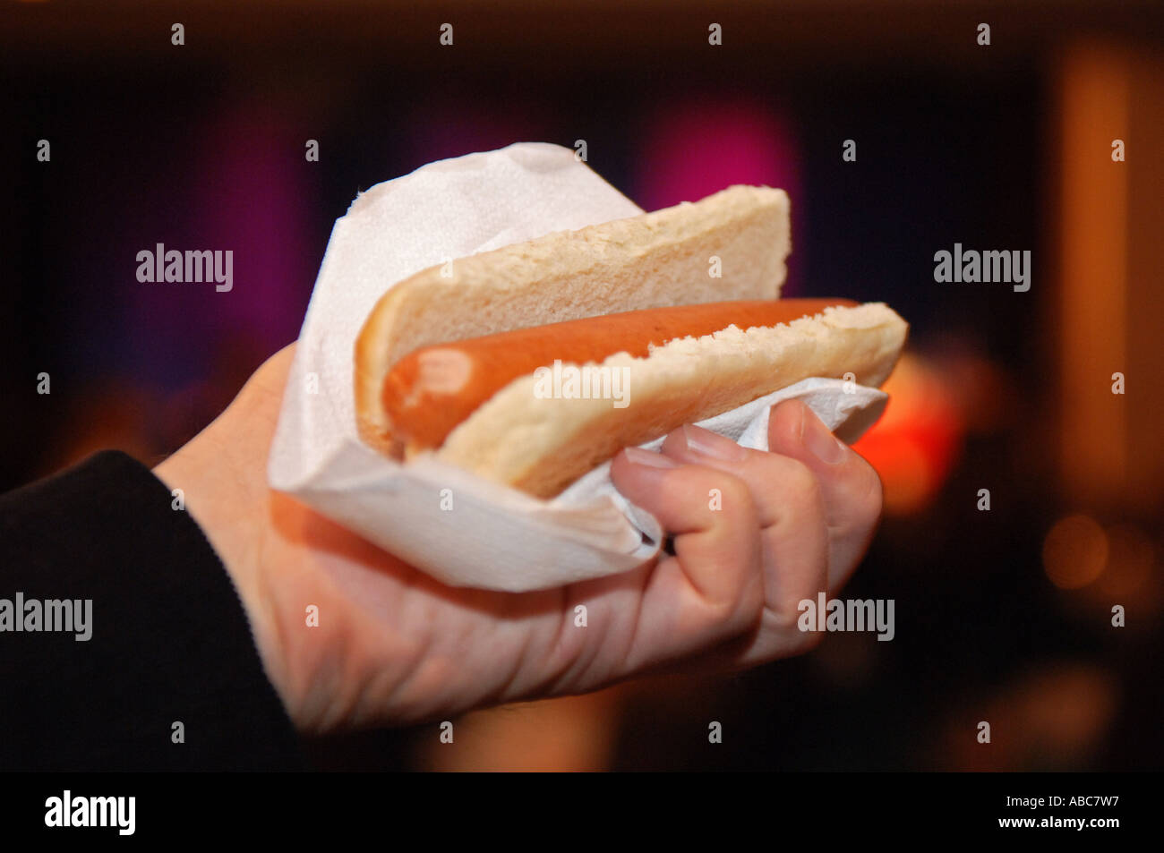 Mano che tiene un hot dog Foto Stock