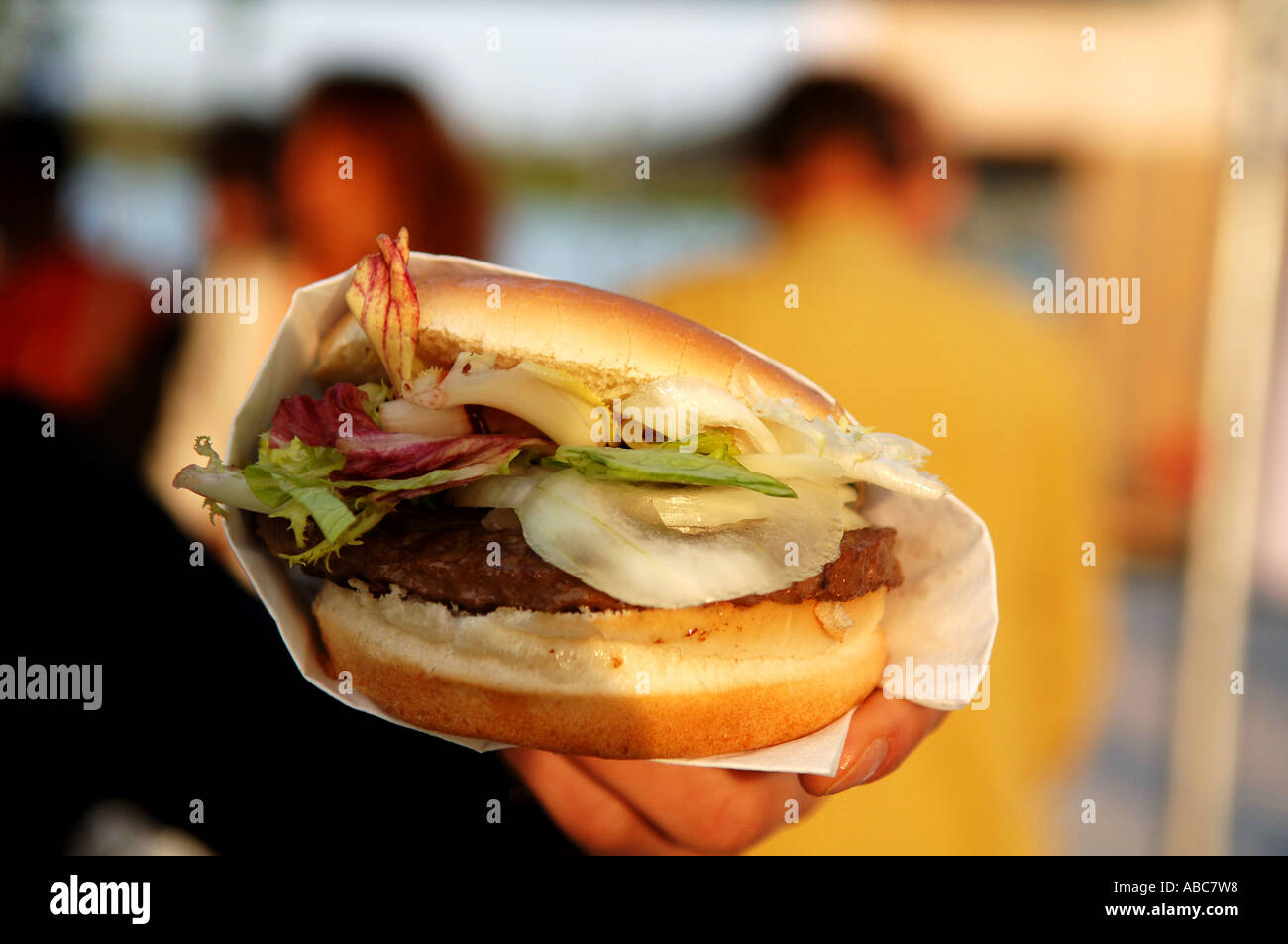 Mano che tiene un burger Foto Stock