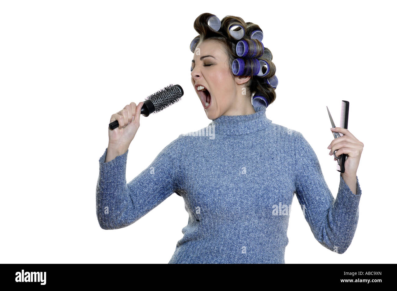 Studio shot ritratti di un giovane divertente e carino donna su uno sfondo bianco a cantare nel suo pennello Foto Stock