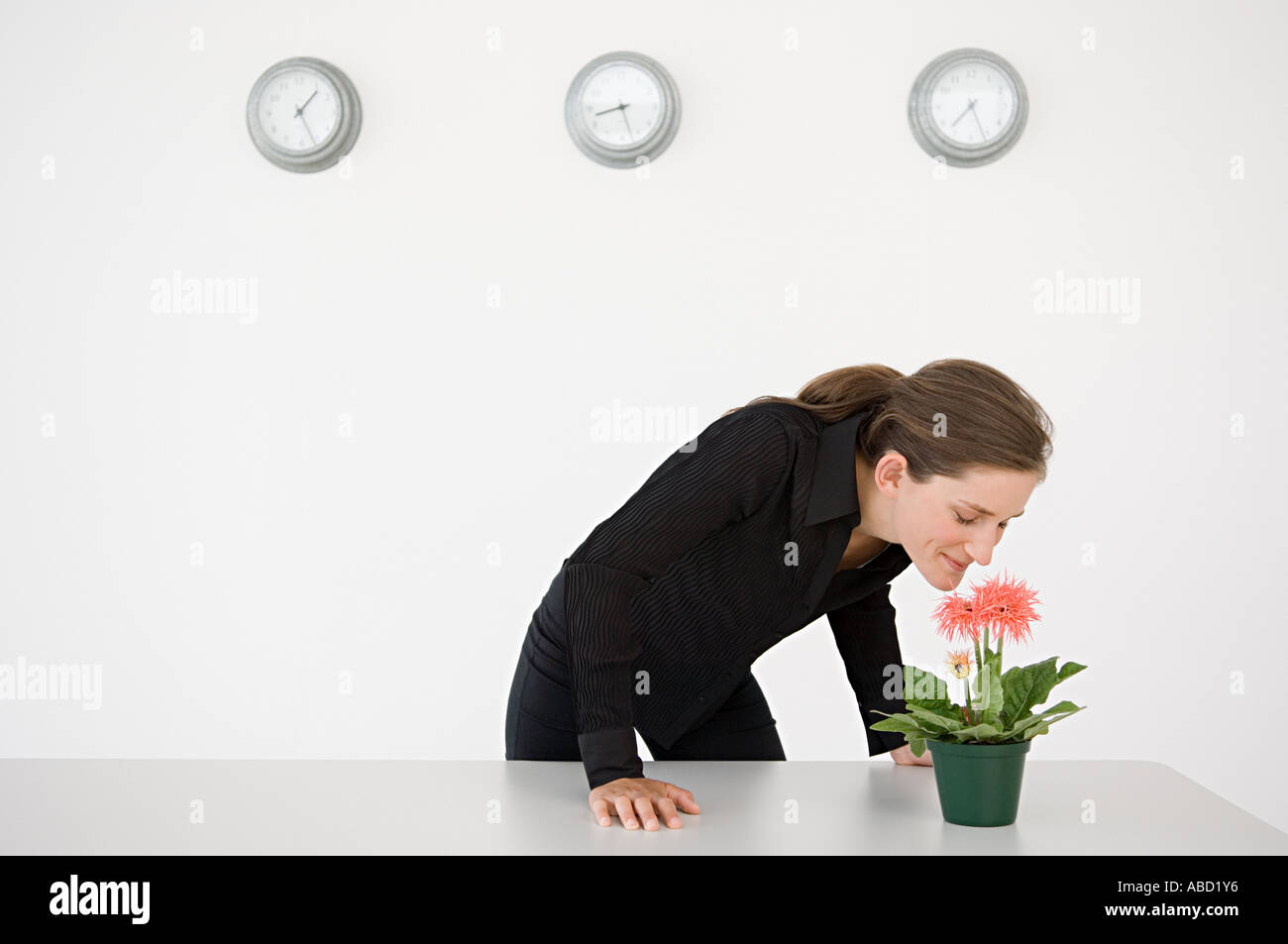 Imprenditrice odorare un fiore Foto Stock