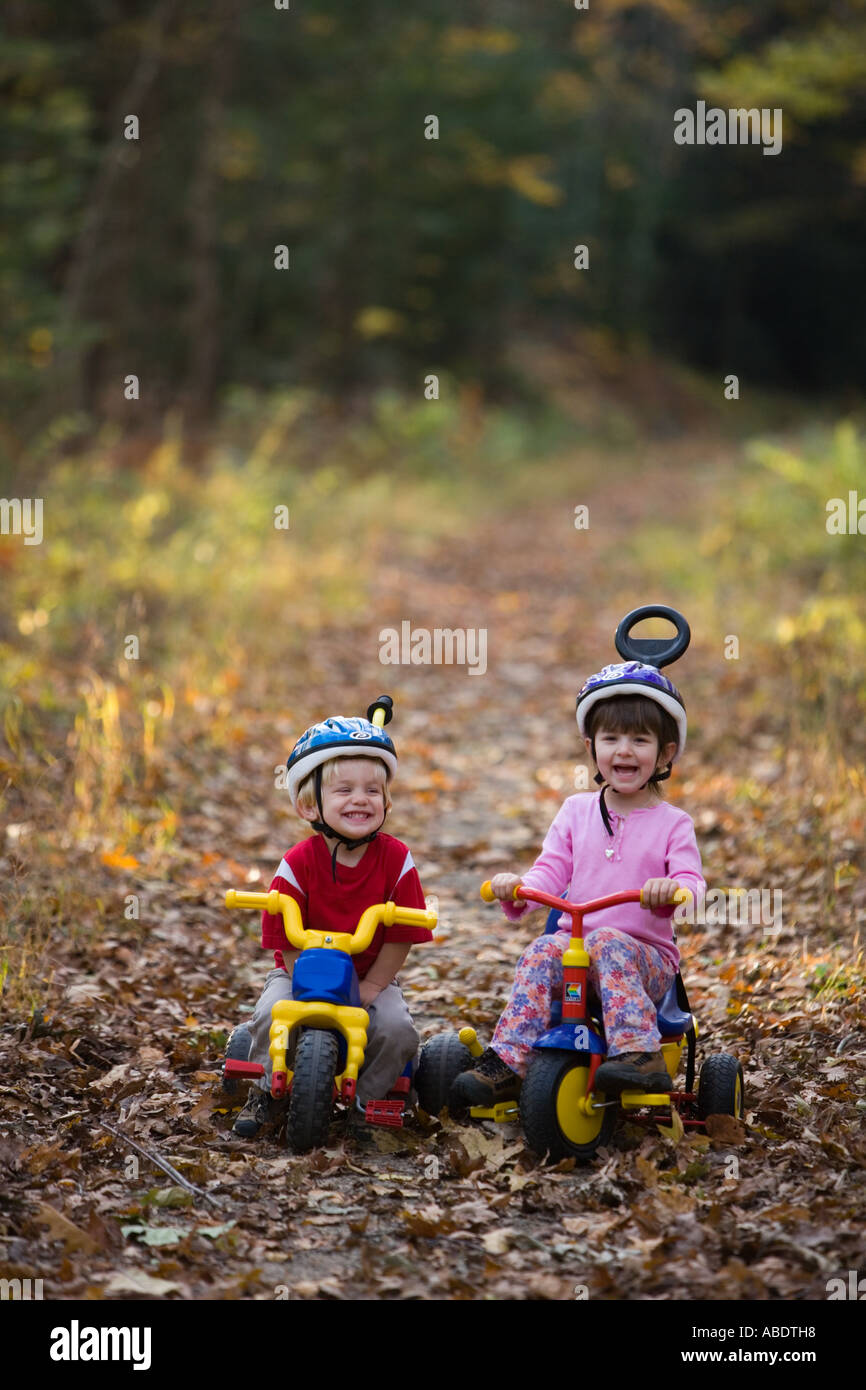 Un giovane ragazzo di età compresa tra 2 e sua sorella 4 anni sulle loro moto Newfields rail trail in Newfields NH caduta Foto Stock