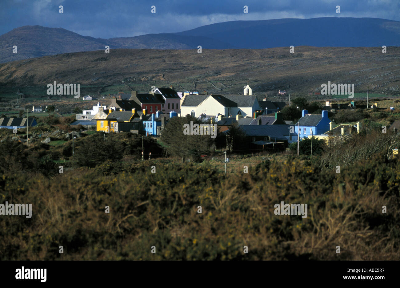 L'Irlanda nella contea di Cork, penisola di Beara, dipinto luminosamente case contro le montagne selvagge di modo atlantico Foto Stock