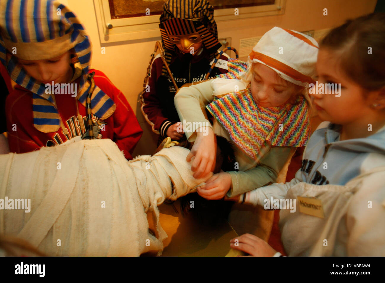 Bambini ricreare imbalsamazione presso il centro di Egitto a Swansea University Foto Stock
