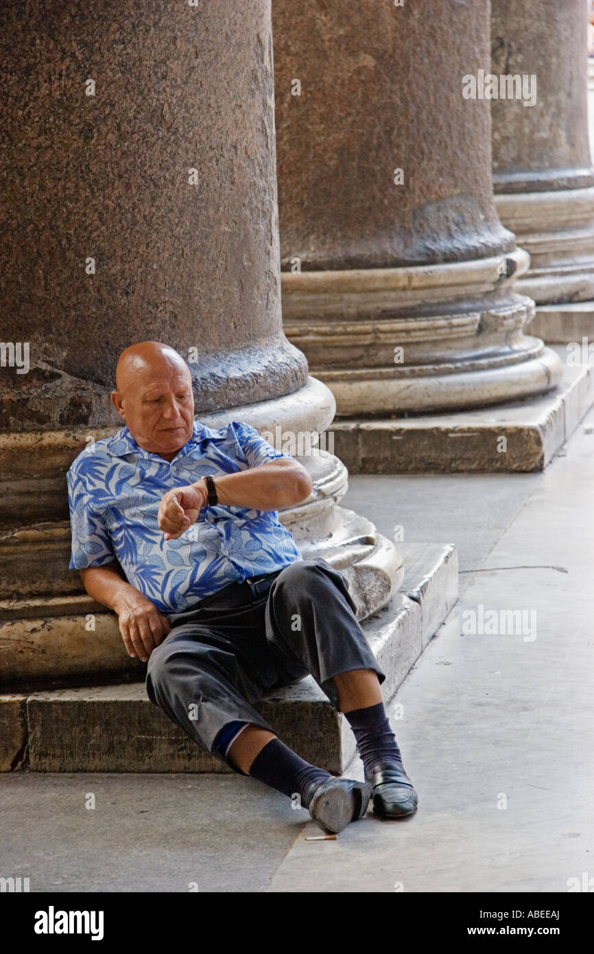 Uomo si siede sotto il portico Pantheon Roma Italia Foto Stock
