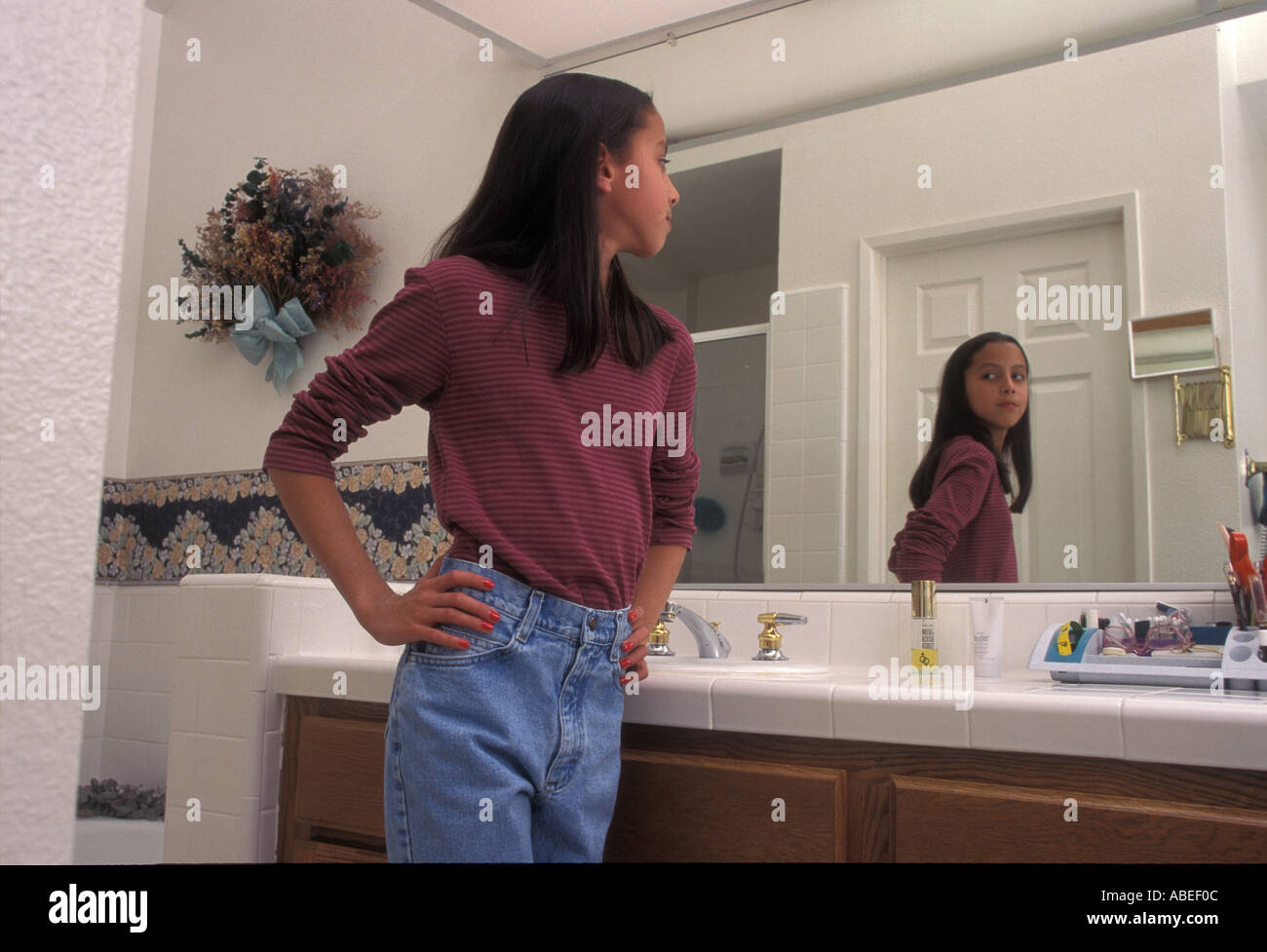 Tween Tween 11-13 anni lei stessa ammirando lo specchio del bagno la riflessione bambini diverse la multietnicità. mixed razziale persona persone POV Foto Stock