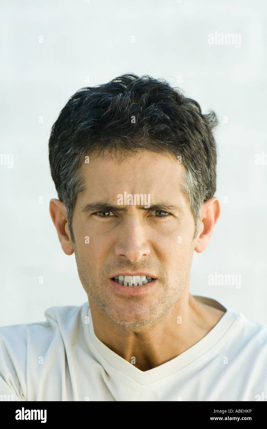 L'uomo scowling in telecamera, testa e spalle, ritratto Foto Stock