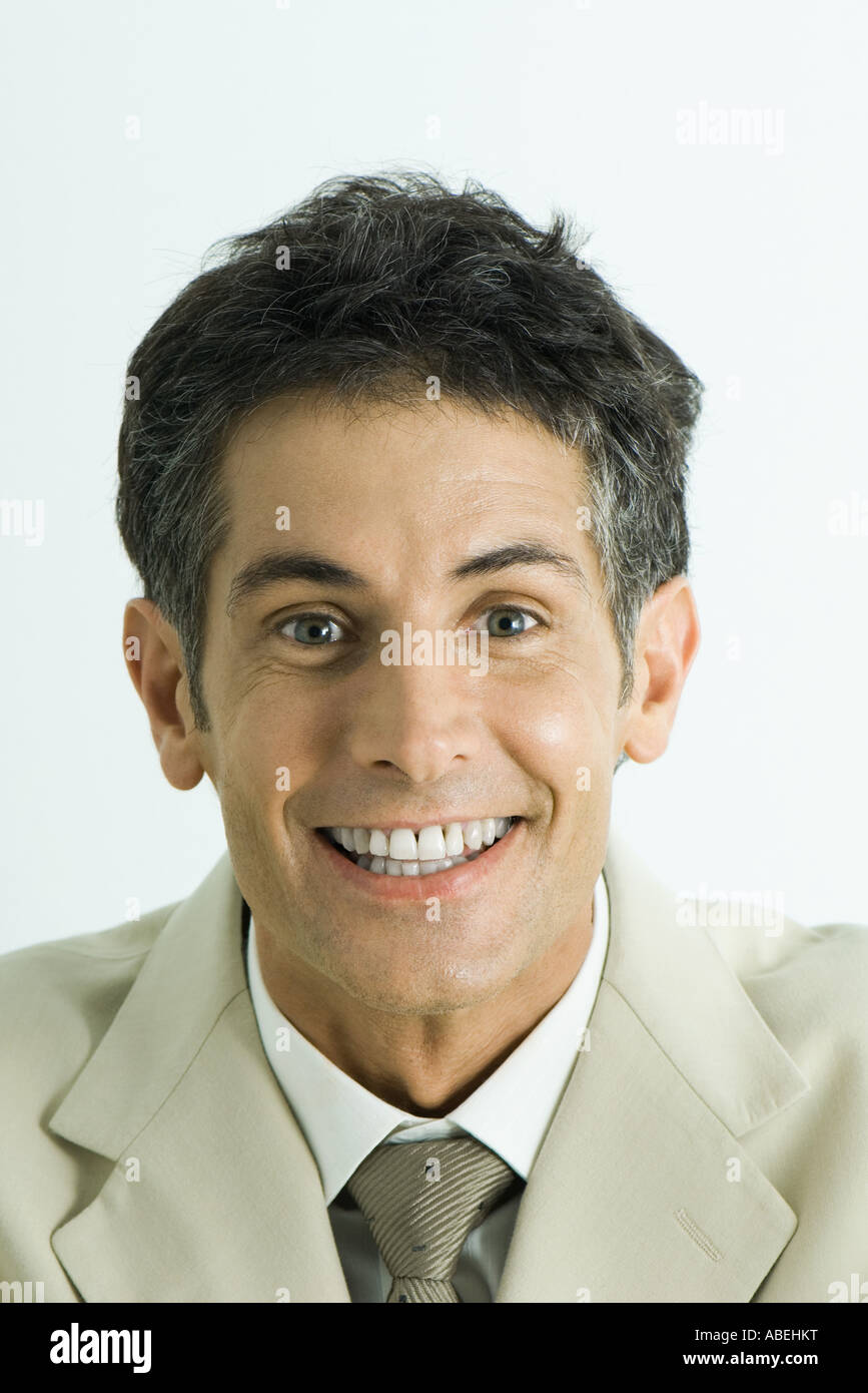 Uomo che guarda in telecamera con sorriso toothy, testa e spalle, ritratto Foto Stock