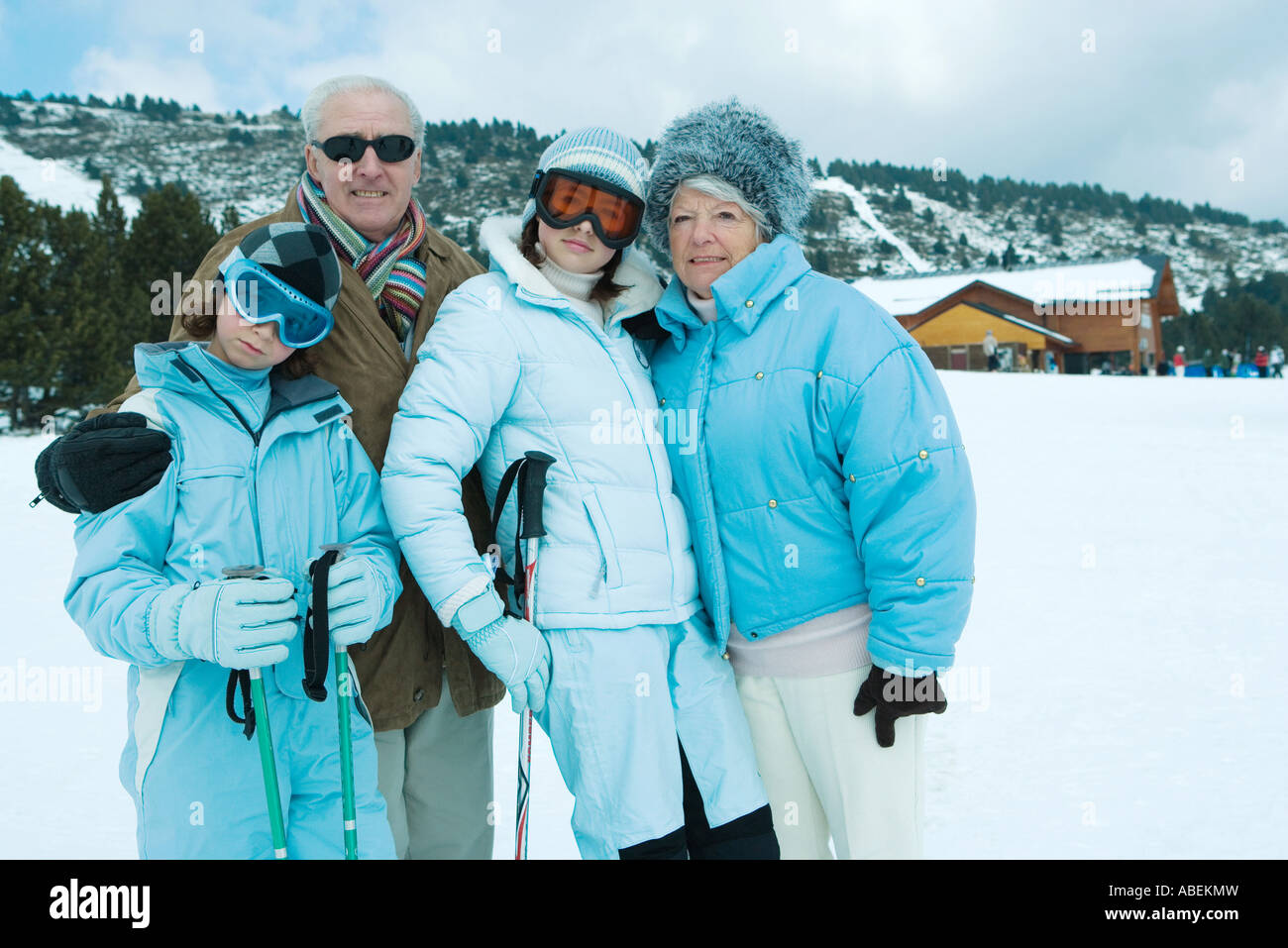 Nonni e nipoti in piedi nel paesaggio innevato, ritratto Foto Stock