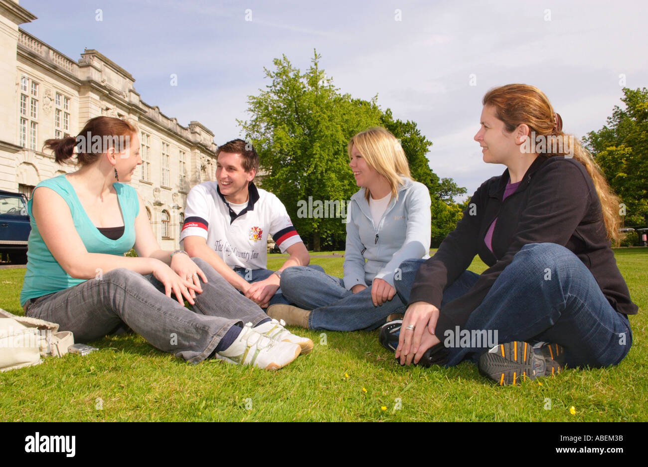 Università di Cardiff gli studenti Relax & chat sul prato in estate il sole presso l'Università di Cardiff Galles del Sud REGNO UNITO Foto Stock