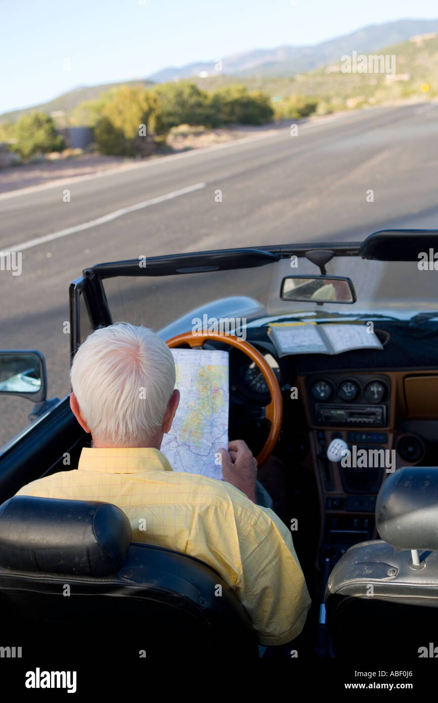 Senior uomo seduto nel convertibile auto sportiva guardando mappa,Santa Fe NM Foto Stock