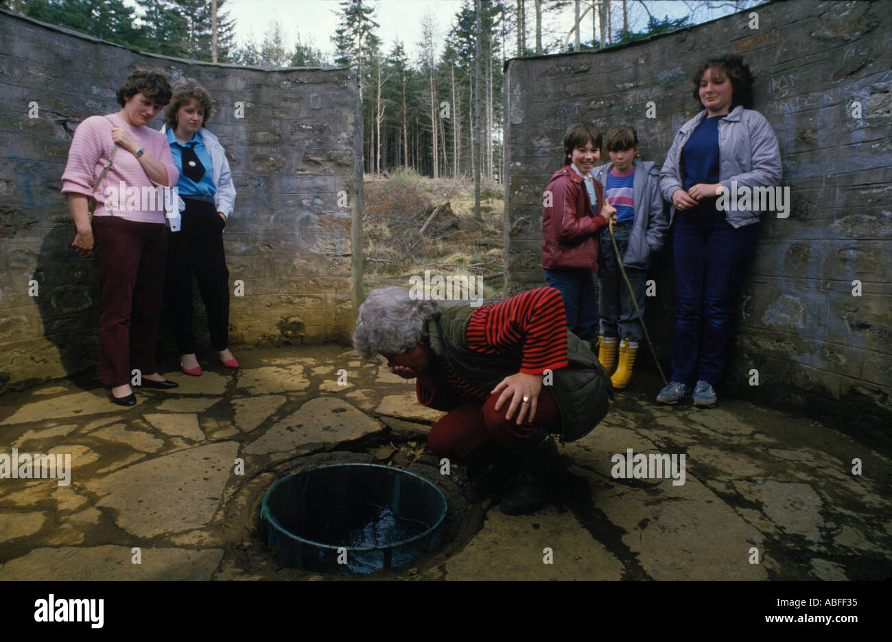 St Marys Well Cloutie Well Culloden Moor Smithton Invernesshire Scozia. Donna che beve acqua di sorgente buona fortuna dal desiderio di bene UK May Day 1990s Foto Stock