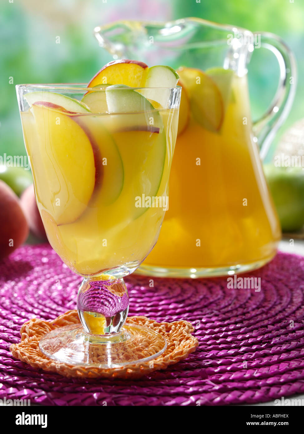 Un bicchiere e brocca di vino bianco Sangria su un tavolo da giardino Foto Stock